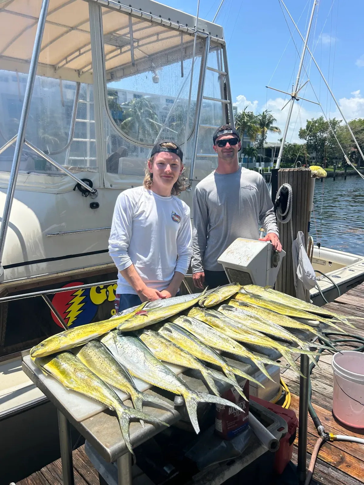 Two anglers behind a full spread of mahi mahi laid out on the Gradyful boat