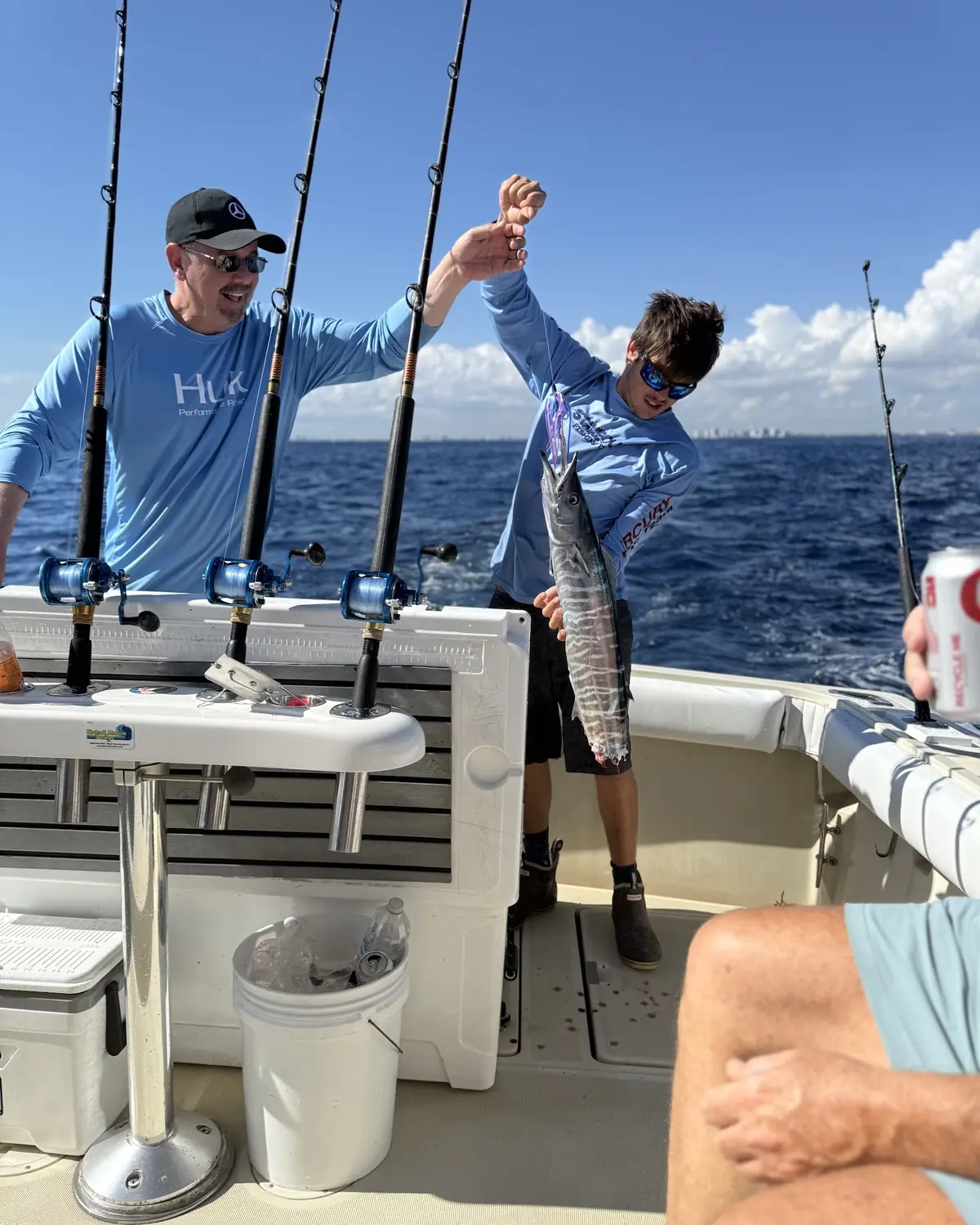 The first mate working the rods on the back deck alongside a guest