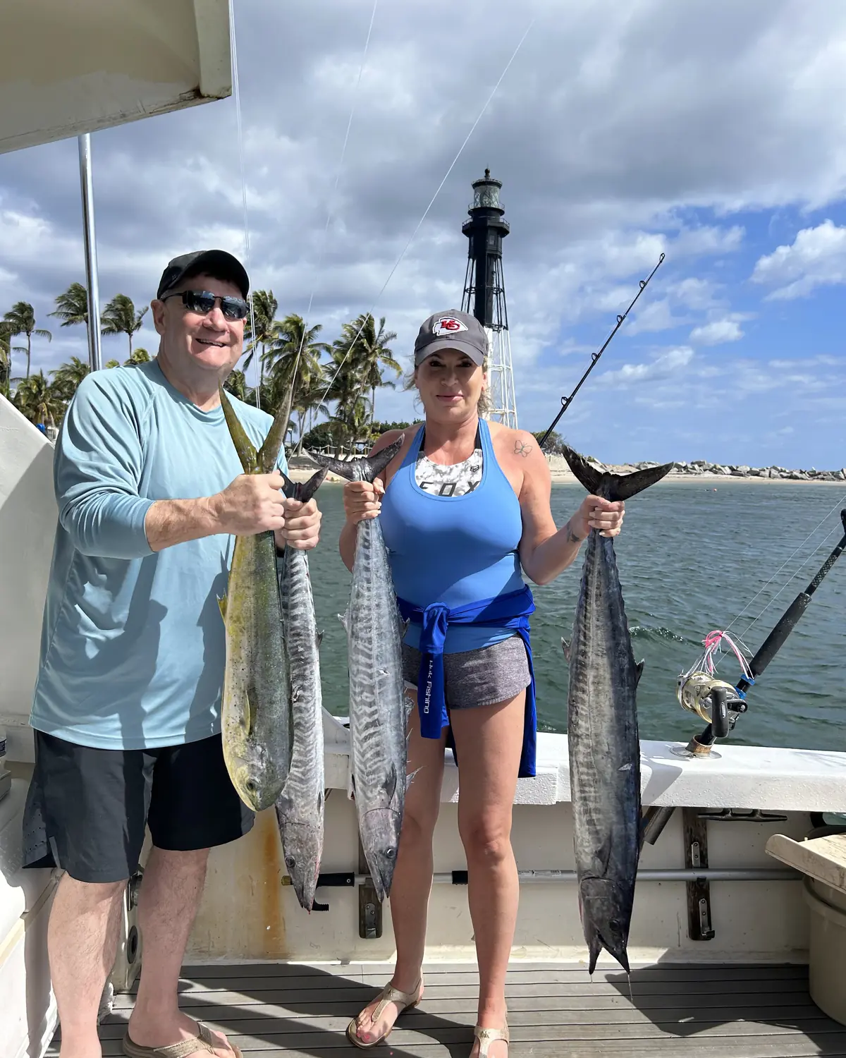 Captain Shawn and guests holding a wahoo and kingfish on the dock